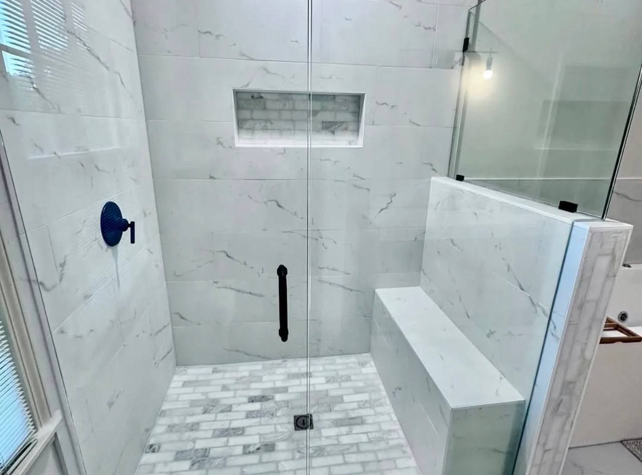 Shower bench, niche, tile, and glass enclosure.